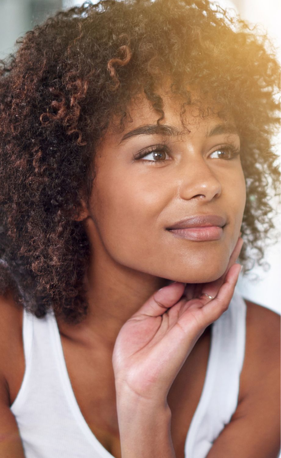 Thoughtful Eatontown med spa model with curly hair and soft expression