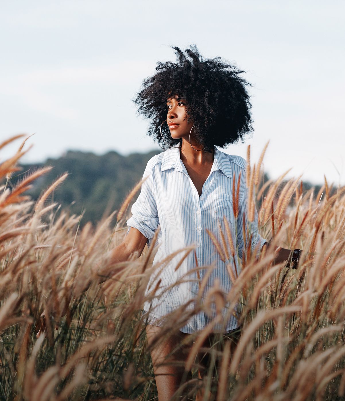 Eatontown med spa model in striped shirt among tall grasses.